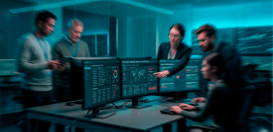 Grupo de pessoas analisando dados em um computador